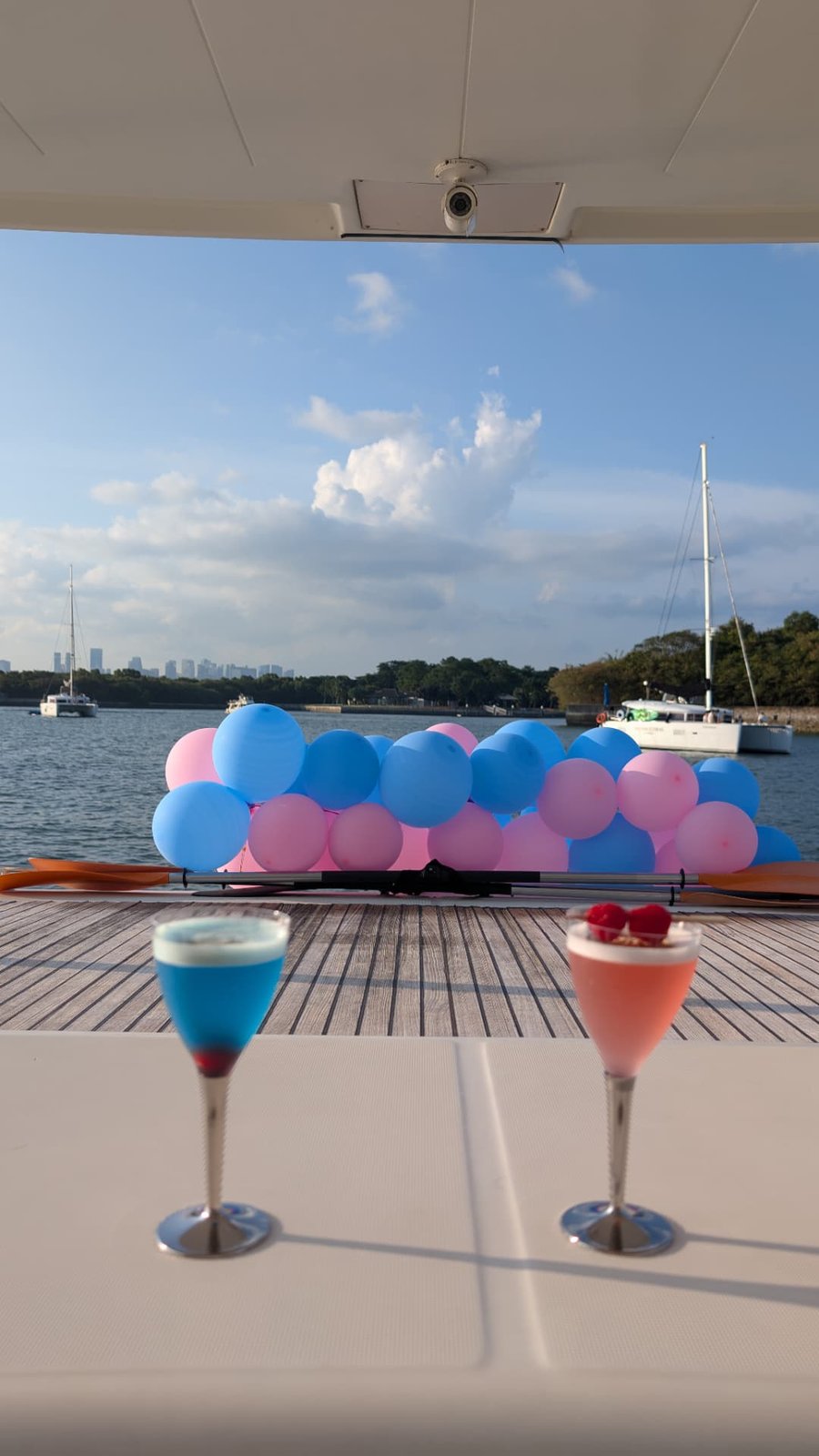 Two colourful yacht party cocktails in coupe glasses on a boat deck in Singapore