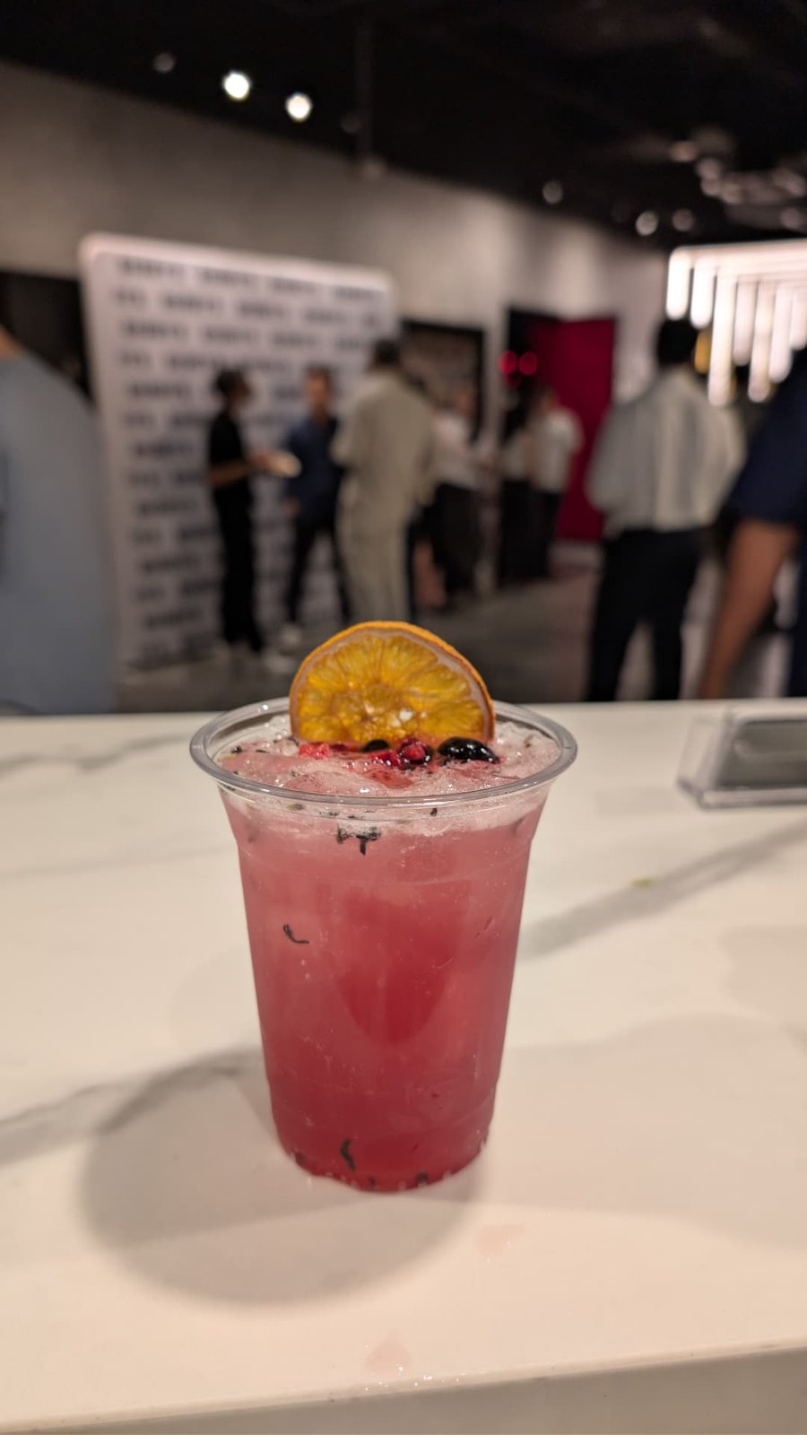 Berry cocktail with dehydrated citrus wheel served at a corporate event bar in Singapore
