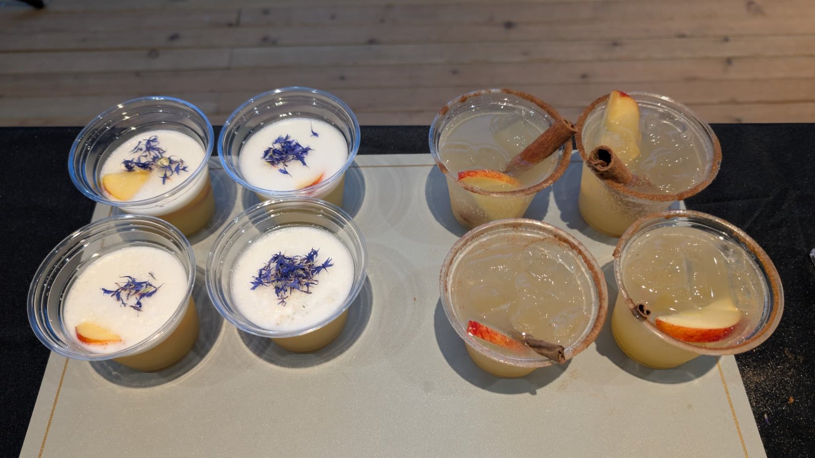 Flight of eight customised cocktails with cinnamon rims, apple slices and floral garnish
